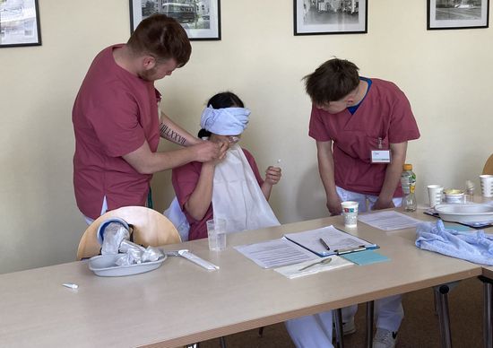 Um sich besser in die Rolle des Patienten hineinversetzen zu können, werden den Azubis während der Übung die Augen verbunden (Foto: Oberhavel Kliniken GmbH).