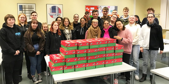 Die Schülerinnen und Schüler der Klassen GPA 23.1 und GPA 23.2 präsentieren stolz ihre Weihnachtsgeschenke für bedürftige Kinder. Foto (2): AGUS Akademie
