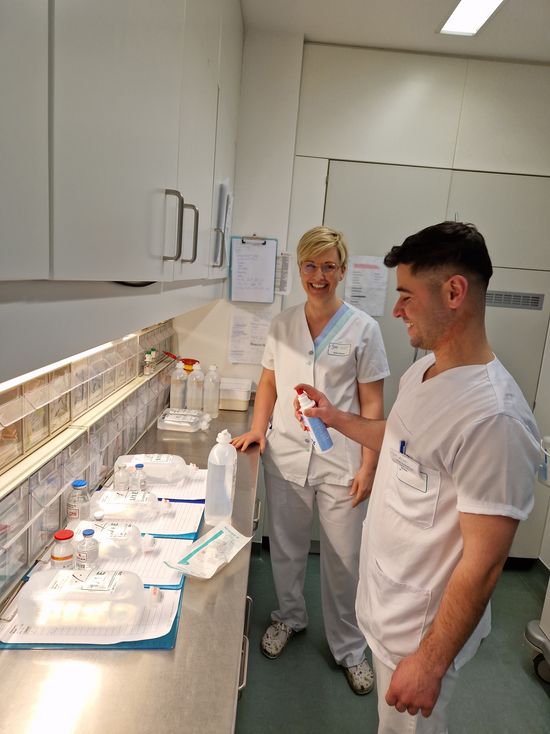 Ausbildungskoordinatorin Heike Risse bereitet mit Alshahud Naji eine Infusion vor