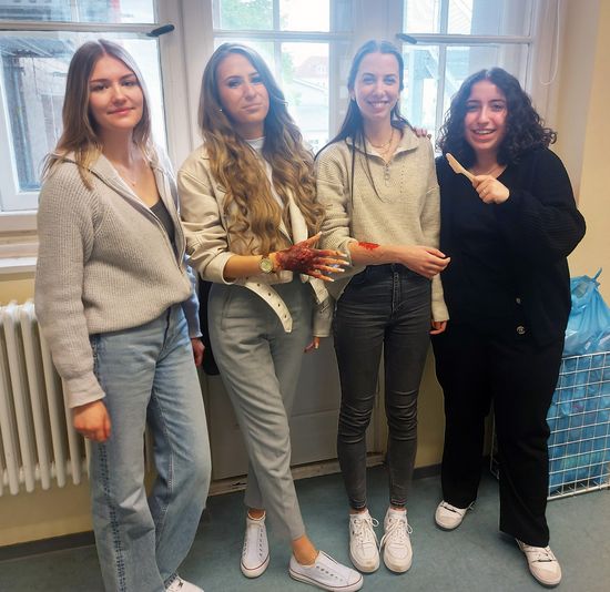 Präsentieren stolz ihre Wunden: Die Schülerinnen Ronja Brandenburg, Anna Wilde, Lea Schlensog und Semsey Aykut aus der Abschlussklasse GPA 21.1 (Foto: AGUS Akademie/Denise Schönberg).